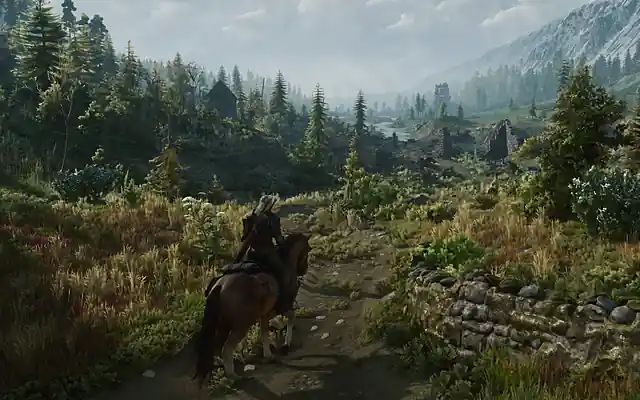 A rider on horseback on a trail through a mountain valley